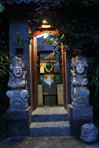 une entrée à une maison avec deux statues en pierre dans l'établissement Pondok Penestanan Villa Ubud, à Ubud