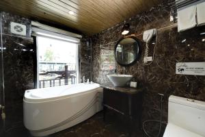 a bathroom with a tub and a sink and a mirror at Amanda cruise 5 star ha long bay in Ha Long +19 photos