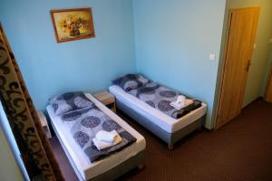 zwei Betten in einem Zimmer mit blauen Wänden in der Unterkunft Beskidek in Gilowice