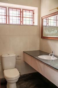 a bathroom with a toilet and a sink at Orma in Cochin +2 photos