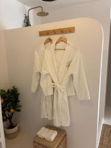 ein weißes Gewand hängt an einer Wand in der Unterkunft Spa2Luxe - Oasis Cachée in Saint-Quentin + 19 Fotos