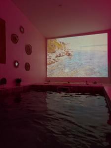 ein Zimmer mit einem großen Gemälde an der Wand in der Unterkunft Spa2Luxe - Oasis Cachée in Saint-Quentin