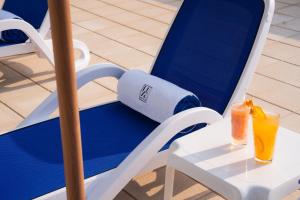 a blue and white chair with two drinks on it at The Luxe Retreat Hotel Apartments in Dubai