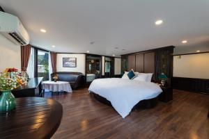 a hotel room with a large bed and a table at Amanda cruise 5 star ha long bay in Ha Long