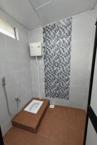 a bathroom with a shower with a toilet in it at DNH Nilam Puri Homestay Unit B in Kota Bharu