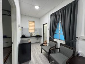 a room with two chairs and a desk and a window at DNH Nilam Puri Homestay Unit B in Kota Bharu