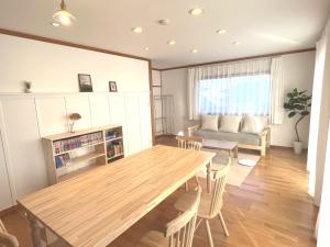 a living room with a wooden table and a couch at Cozy House Azumino in Azumino