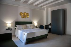 a bedroom with a large bed and a desk at Luxury B&B Maison Madre in the historic center of Avola in Avola