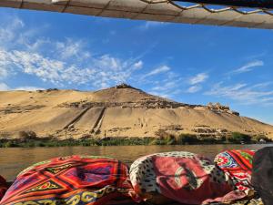 a view of a mountain from a boat in the water at Aswan all-inclusive private felucca in Aswan