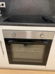 a stove top oven in a white kitchen at Cosy New Studio 2 min RER B in Aulnay-sous-Bois