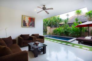 a living room with furniture and a swimming pool at The Yubi Boutique Villas Seminyak - CHSE Certified in Seminyak