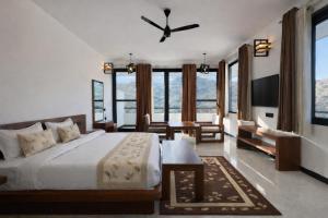 a bedroom with a bed and a large window at The HighGarden Resort in Udaipur