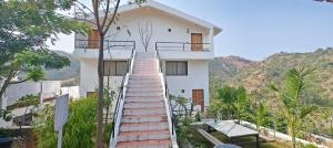 a white house with stairs leading up to it at The HighGarden Resort in Udaipur