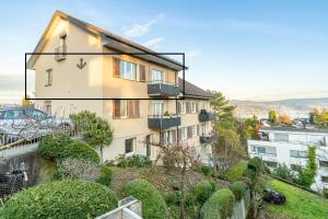 an apartment building with a balcony and plants at Cocoa Suite · Kilchberg in Kilchberg