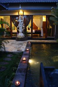 a swimming pool with a statue in a house at Pondok Penestanan Villa Ubud in Ubud