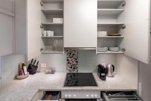 a small kitchen with white cabinets and a stove at Cocoa Suite · Kilchberg in Kilchberg +20 photos
