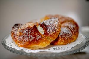 two donuts on a glass plate with powdered sugar at Luxury B&B Maison Madre in the historic center of Avola in Avola +41 photos