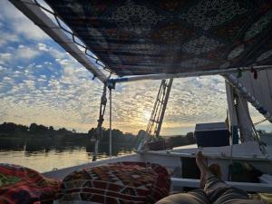 a person is laying on the back of a boat at Aswan all-inclusive private felucca in Aswan +14 photos