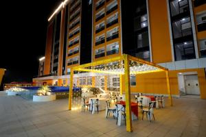 an outdoor patio with tables and chairs and lights at Hotel Nimantrana in Noida