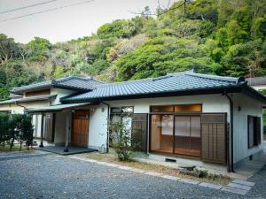 a small house with a mountain in the background at 甚兵衛邸 in Hirado