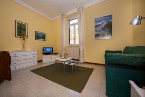 a living room with a green couch and a tv at Bella Varenna in Varenna