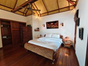 a bedroom with a bed and a ceiling fan at Private Balinese Bungalow for 2 - Shared pool - Lamai Koh Samui in Nathon Bay