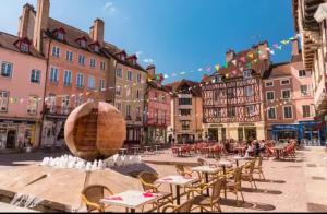a town square with tables and chairs and a water fountain at Le Cosy in Chalon-sur-Saône