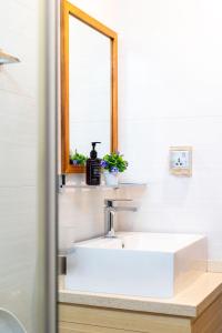 a bathroom with a white sink and a mirror at Fen Villa in Dharavandhoo +22 photos