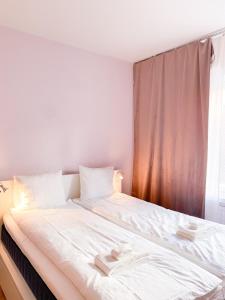 a bedroom with a large white bed with a window at Studio Flamingo in Helsinki