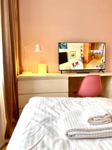 a bedroom with a bed and a desk with a mirror at Studio Flamingo in Helsinki