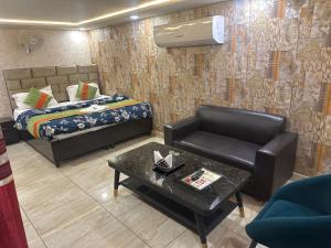 a room with a bed and a chair and a table at Hotel Crown Inn in Jalandhar