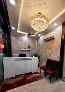a lobby with a reception desk and a chandelier at Hotel Crown Inn in Jalandhar