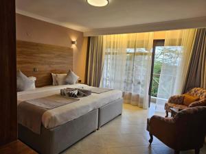 a bedroom with a large bed and a large window at Lukenya Motorcross in Machakos +19 photos