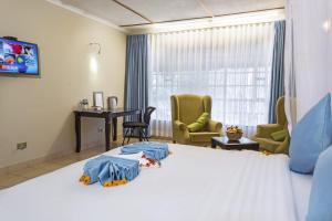 a hotel room with a bed and a desk and chairs at Lukenya Motorcross in Machakos