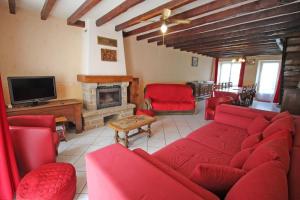 a living room with red furniture and a fireplace at Champblanc in Arnac-la-Poste