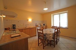 a kitchen with a table and chairs and a window at Champblanc in Arnac-la-Poste