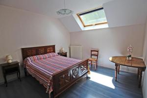a bedroom with a bed and a table and a window at Champblanc in Arnac-la-Poste