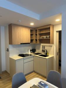 a kitchen with white cabinets and a table and chairs at Laguna SkyPark in Laguna Phuket