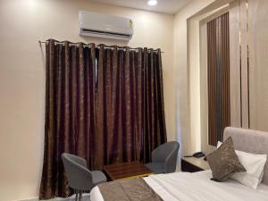 a room with a bed and a window with curtains at Hotel Highway Retreat in Gajraula