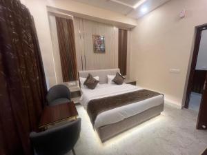 a bedroom with a bed and a desk and a chair at Hotel Highway Retreat in Gajraula +4 photos