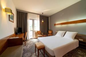 a hotel room with a large bed and a desk at Hotel Munsch Restaurant & Wellness, Colmar Nord - Haut-Koenigsbourg in Saint-Hippolyte