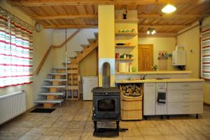 a kitchen with a stove and a staircase at Atpūtas vieta Upes Sausītes in Sidrabiņi