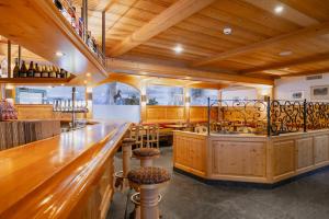 eine Bar in einem Restaurant mit Holzböden und Holzdecken in der Unterkunft Alpenresort Eienwäldli Camping in Engelberg