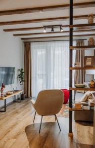a living room with a chair in front of a window at Relax Balaton Apartmanok in Balatonfüred