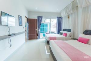 a hotel room with two beds and a flat screen tv at สายป่าน พลูวิลล่า in Cha Am +35 photos