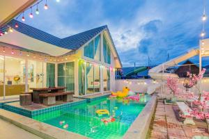 a house with a swimming pool in the backyard at สายป่าน พลูวิลล่า in Cha Am