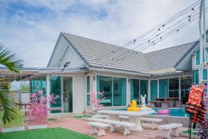 a house with a picnic table and a pool at สายป่าน พลูวิลล่า in Cha Am
