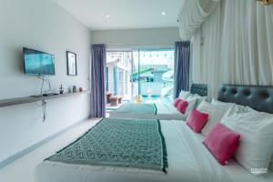 a large bedroom with a large bed with pink pillows at สายป่าน พลูวิลล่า in Cha Am