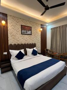 a bedroom with a large bed with blue and white pillows at MK House in Greater Noida