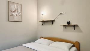 a bedroom with a bed and a lamp on a wall at Central Station Apartments in Podgorica